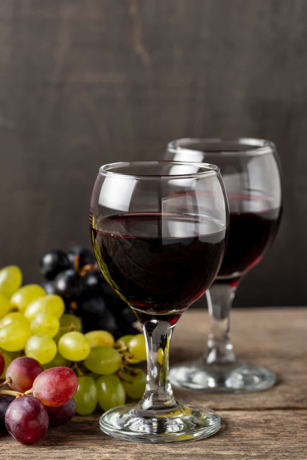 glasses-with-red-wine-beside-organic-grapes